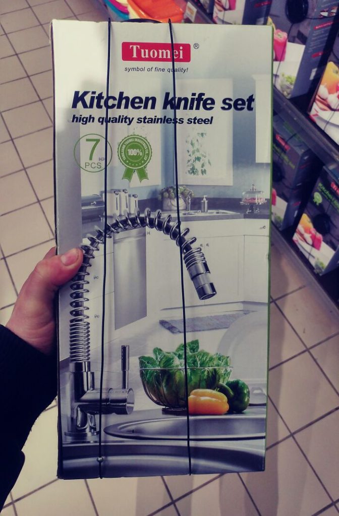 A hand holding a box of kitchen knife Description automatically generated