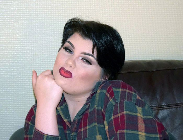 A person with her hand on her chin Description automatically generated