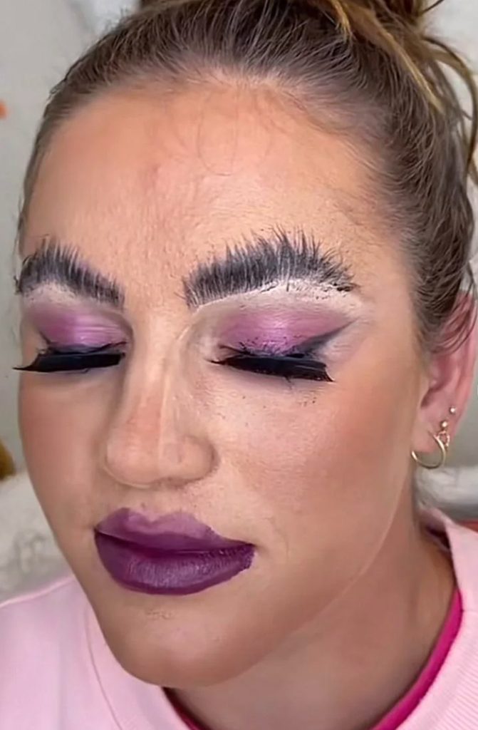 A person with purple makeup Description automatically generated